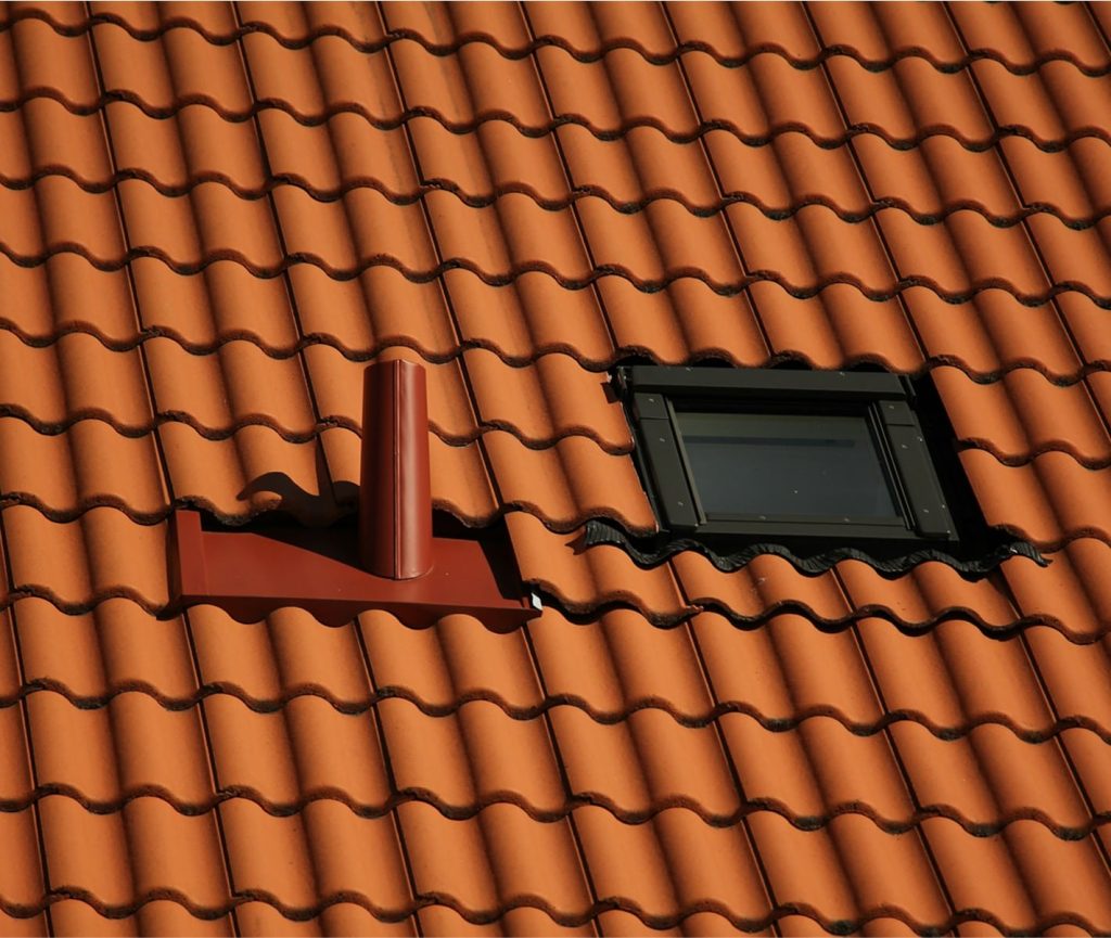 Roof window fitted into a tiled roof with flashing