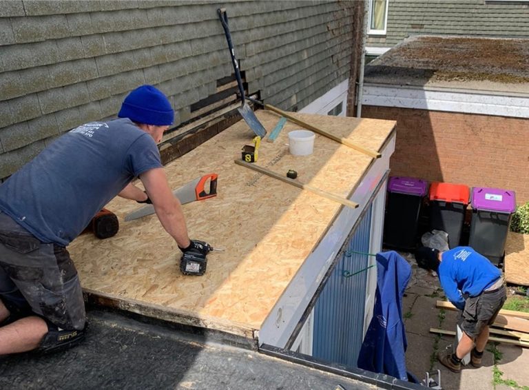 Roofers working on a new flat roof deck